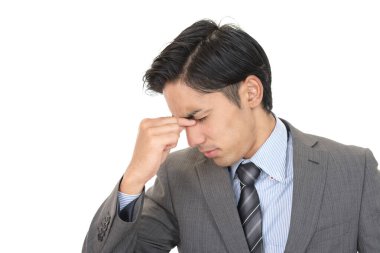 Yorgun gözlerini tutan takım elbiseli bir adam.