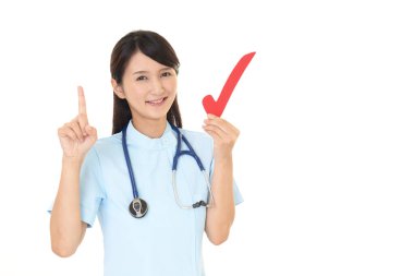 Gülen hemşire kontrol işareti tutuyor.