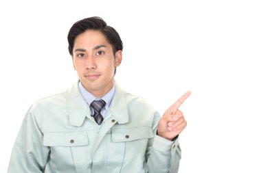 Gülümseyen bir erkek işçi mekanı işaret ediyor.