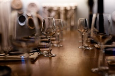 Şatafatlı yemek masaları ve cam eşyalar, bardağa şarap doldurmak. Güzel bulanık arkaplan. Tatil düğünü için hazırlık. Lüks bir restoran..