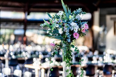 Şatafatlı yemek masaları ve cam eşyalar, bardağa şarap doldurmak. Güzel bulanık arkaplan. Tatil düğünü için hazırlık. Lüks bir restoran..