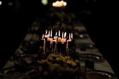 Şatafatlı yemek masaları ve cam eşyalar, bardağa şarap doldurmak. Güzel bulanık arkaplan. Tatil düğünü için hazırlık. Lüks bir restoran..