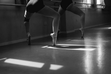 Doğal ışık ve gölgeli bir stüdyoda dans eden balerin..