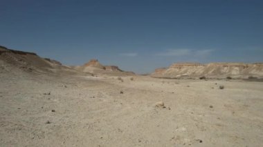 Engin İsrail çölünün çarpıcı 4K hava görüntüleri, geniş kum tepecikleri, engebeli kayalık arazi ve berrak çöl gökyüzünün altında geniş açık araziler. 
