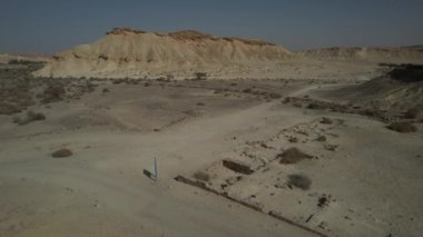 Engin İsrail çölünün çarpıcı 4K hava görüntüleri, geniş kum tepecikleri, engebeli kayalık arazi ve berrak çöl gökyüzünün altında geniş açık araziler. 