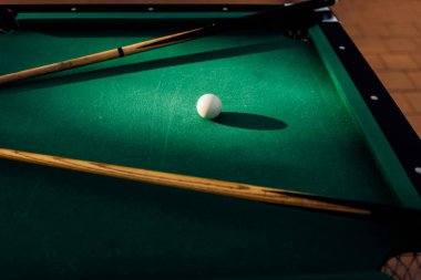 Bir bilardo masası, dağınık bilardo topları, bir ıstaka sopası, ve aksesuarlar dinamik bir oyun sahnesinde çekildi. Ekipmanlara yönelik ayrıntılı odak noktası, bilardonun hem spor hem de boş zaman aktivitesi olarak zamansız cazibesini vurguluyor.