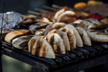 Bir barbekü etkinliği sırasında tahta kesme tahtasıyla taze dilimlenen sulu füme et eti. Yakın plan taze et, kavrulmuş bir kabuk, doğal ışık altında yakalanır. 