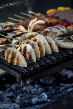 Bir barbekü etkinliği sırasında tahta kesme tahtasıyla taze dilimlenen sulu füme et eti. Yakın plan taze et, kavrulmuş bir kabuk, doğal ışık altında yakalanır. 