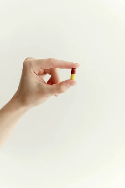 Zbliżenie Ręki Trzymającej Tabletkę Palcach Białym Tle Jedna Tabletka Czerwono — Zdjęcie stockowe