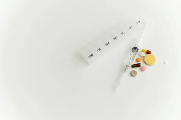 白色背景的药物 一个题字的地方 一个注射器和一盒药丸一天 一种维生素片 问题处理 皮肤科 — 图库照片