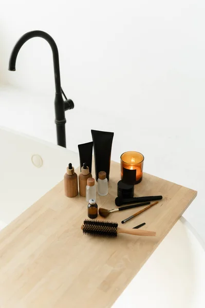 a wooden comb lies on a wooden stand with bathroom accessories for body care. bathroom concept