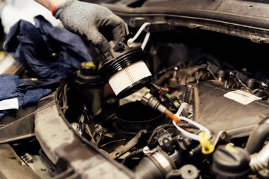 Bir otomobil tamircisi yeni yakıt filtresini modern bir dizel motorla değiştirir. Araba servisi ya da önleyici bakım. makine bakımı