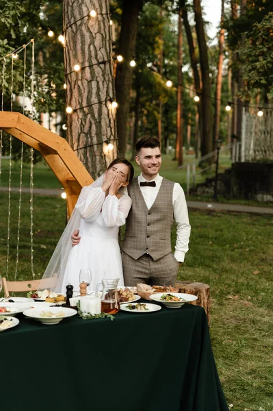 Noiva Noivo Jovens Bonitos Estão Sentados Mesa Casamento Fundo Arco — Fotografia de Stock