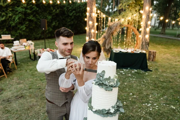 Uma Noiva Feliz Seu Marido Noivo Cortar Bolo Casamento Enquanto — Fotografia de Stock