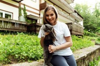 Yün döken bir kediyi tarayan bir elin yakın çekimi. Kedi fırçası. dışarıyı tarıyor