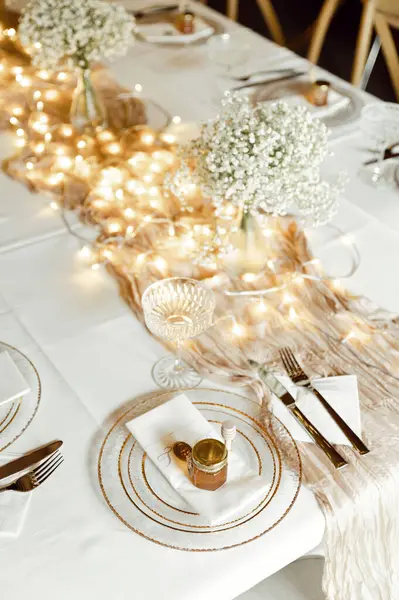 beautiful wedding tableware lies on a white table. gold spoons and forks. wedding decorations. banquet table. empty plate