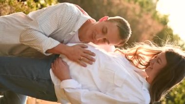 Koca başını hamile karnına doğru eğdi ve bebeğin sesini dinledi. Hamile kadın kocasıyla mutlu. güzel hamilelik