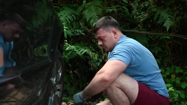 Ένας Άντρας Αλλάζει Λάστιχο Αυτοκινήτου Ενώ Είναι Στο Δρόμο Αντικατάσταση — Αρχείο Βίντεο
