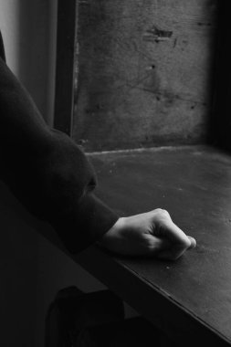 Adam pencere eşiğine yaslanmış saldırgan bir hareket sergiliyor.