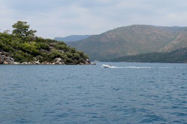 Dağların arkasında, denizde bir gemi.