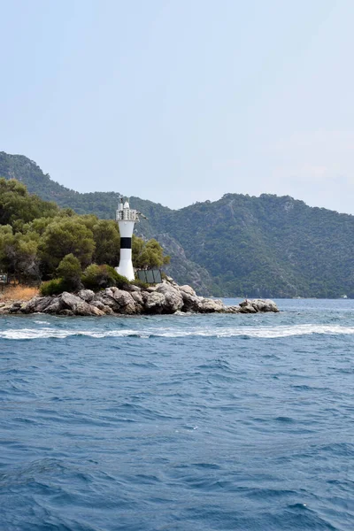 lighthouse on the coast of the sea in the Turkey. Lighthouse on a background of green mountains and sea