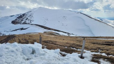 Dağlardaki manzara çok güzel. Dağın tepesinde kar var.
