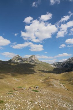 Karadağ 'ın kuzeyindeki Sedlo Dağı. Dağların eteğindeki evler. Gökyüzüne ve bulutlara karşı sıradağlar