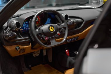 Steering wheel and interior Ferrari F8 Tributo Spider. view through the open door. Katowice, Poland, 29.10.2019