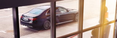 Lüks Mercedes S sınıfı, boş bir yeraltı otoparkında duruyor. Binanın içinden, pencerelerden bak. Katowice, Polonya - 02.02.2021