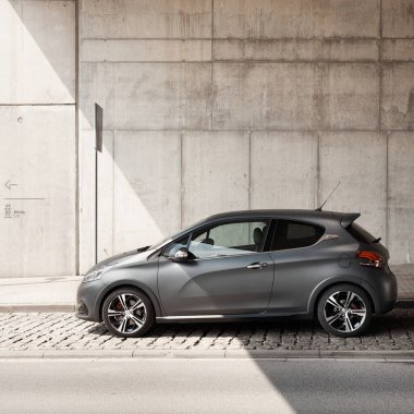 Grey Peugeot 208 GTI orijinal Matt Cila ile Silezya Müzesi 'nin beton duvarının altında duruyor. Tarikat kapağı, hızlı ve çevik. 1.6l, 208 hp, 6.5 s 0-100km Katowice, Polonya-05.05.2016