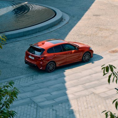 NOSPR konser salonunun önündeki kırmızı BMW M135i. Üst Manzara. Model F40, 2019 'dan üretildi. 306 HP motoru, hızlanma 0-100 km-saat - 4.8 s Katowice, Poland- 09.16.2020