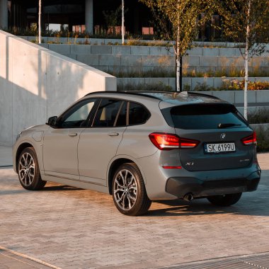 BMW X125, hibrit, fişe takılı araba, modern bir binanın yanına park edilmiş. İki motorun toplam gücü 220HP. Elektrik aralığı 52 km Katowice, Poland- 07.30.2021