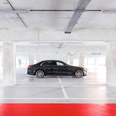 Lüks Mercedes S sınıfı, boş bir yeraltı otoparkında duruyor. Siluetin yan görüntüsü. Katowice, Polonya - 02.02.2021