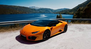 Turuncu bir Lamborghini Huracan, V10 motoru, 580 HP. Dağlarda bir gölün kenarına park edilmiş bir araba. Gransherad, Norveç. 04.06.2016