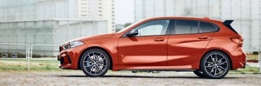 Silezya Müzesi 'nin önündeki kırmızı BMW M135i. Model F40, 2019 'dan üretildi. 306 HP motoru, ivme 0-100 km-saat - 4.8 s Katowice, Polonya, 09.16.2020