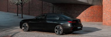 BMW 7 Serisi, G70, modern premium limuzin. Filarmoni orkestrasının arka planındaki araba. 2023 'ten beri satışta. Polonya, Katowice 03.05.2023