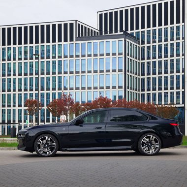 BMW 7 Serisi, G70, modern premium limuzin. Ofis binasının arka planındaki araba. 2023 'ten beri satışta. Polonya, Katowice 03.05.2023