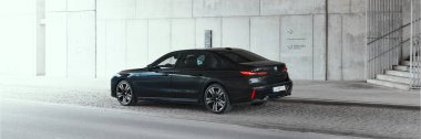 BMW 7 Serisi, G70, modern premium limuzin. Beton bir duvarın arkasında. 2023 'ten beri satışta. Polonya, Katowice 03.05.2023