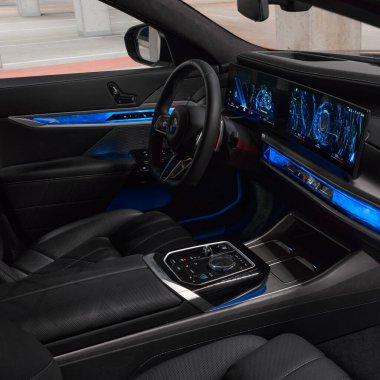 Açık yolcu kapısından bakıldığında BMW 7 serisinin mavi ışıklı iç ve ön paneli. BMW 7 Serisi, G70, modern premium limuzin. 2023 'ten beri satışta. Polonya, Katowice 03.05.2023