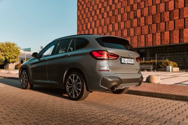 BMW X125, hibrit, fişe takılı araba, modern bir ofis binasının yanına park edilmiş. İki motorun toplam gücü 220HP. Elektrik aralığı 52 km Katowice, Poland- 07.30.2021