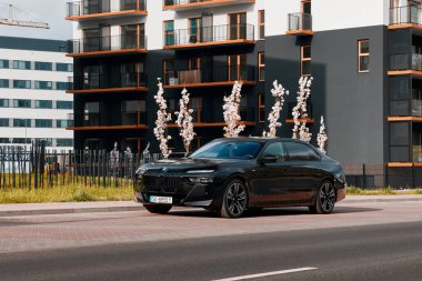 BMW 7 Serisi, G70, modern premium limuzin. Konutların arka planında bir araba. 2023 'ten beri satışta. Polonya, Katowice 03.05.2023