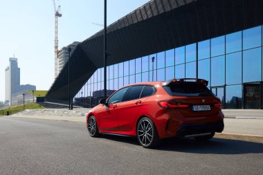 Uluslararası Kongre Merkezi binasının önündeki kırmızı BMW M135i. Dikiz aynası. Model F40. 306 HP motoru, hızlanma 0-100 km-saat - 4.8 s Katowice, Poland- 09.16.2020