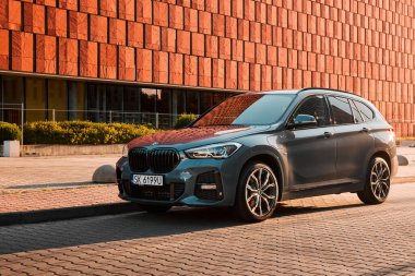 BMW X125, hibrit, fişe takılı araba, modern bir ofis binasının yanına park edilmiş. İki motorun toplam gücü 220HP. Elektrik aralığı 52 km Katowice, Poland- 07.30.2021