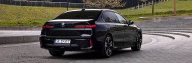 BMW 7 Serisi, G70, modern premium limuzin. Filarmoni orkestrasının arka planındaki araba. 2023 'ten beri satışta. Polonya, Katowice 03.05.2023