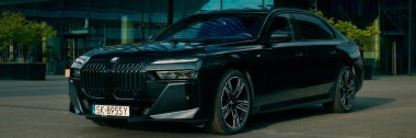 BMW 7 Serisi, G70, modern premium limuzin. Ofis binasının arka planındaki araba. 2023 'ten beri satışta. Polonya, Katowice 03.05.2023