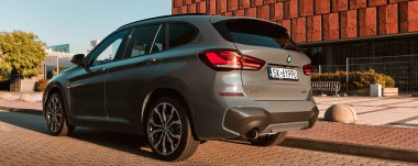 BMW X125, hibrit, fişe takılı araba, modern bir ofis binasının yanına park edilmiş. İki motorun toplam gücü 220HP. Elektrik aralığı 52 km Katowice, Poland- 07.30.2021