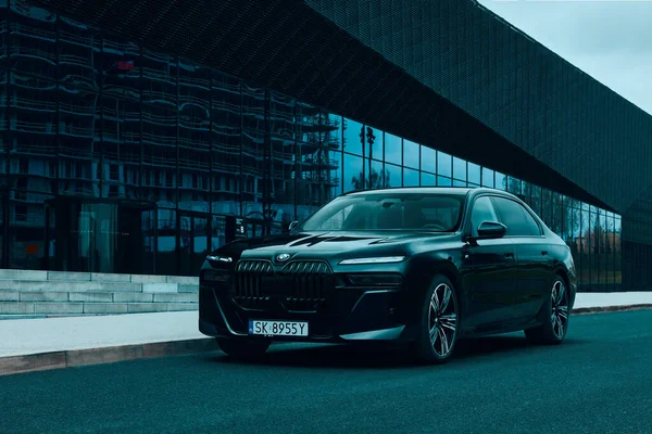 BMW 7 Serisi, G70, modern premium limuzin. Modern binanın arka planında. 2023 'ten beri satışta. Polonya, Katowice 03.05.2023