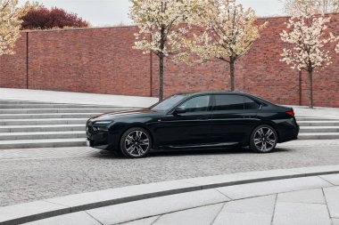 BMW 7 Serisi, G70, modern premium limuzin. Filarmoni orkestrasının arka planındaki araba. 2023 'ten beri satışta. Polonya, Katowice 03.05.2023