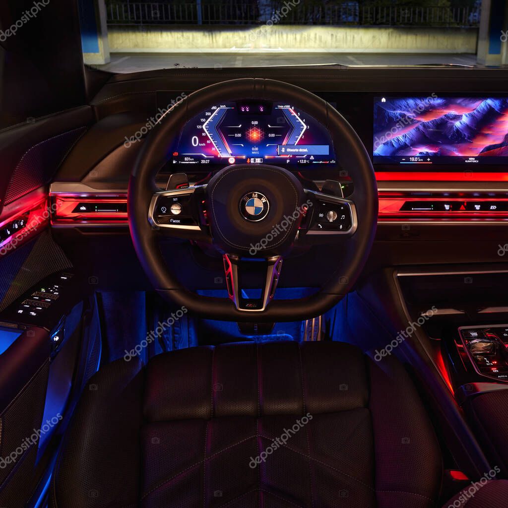 BMW 7 Series. Colorfully illuminated interior of the car, view centrally on the steering wheel from the driver's position. Model G70, a modern premium limousine. On sale from 2023. Poland, Katowice 03.05.2023