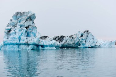 İzlanda 'da bir buzdağı. Jokulsarlon gölüne akan bir buzdağı, buzulun ön tarafından ayrılmış..